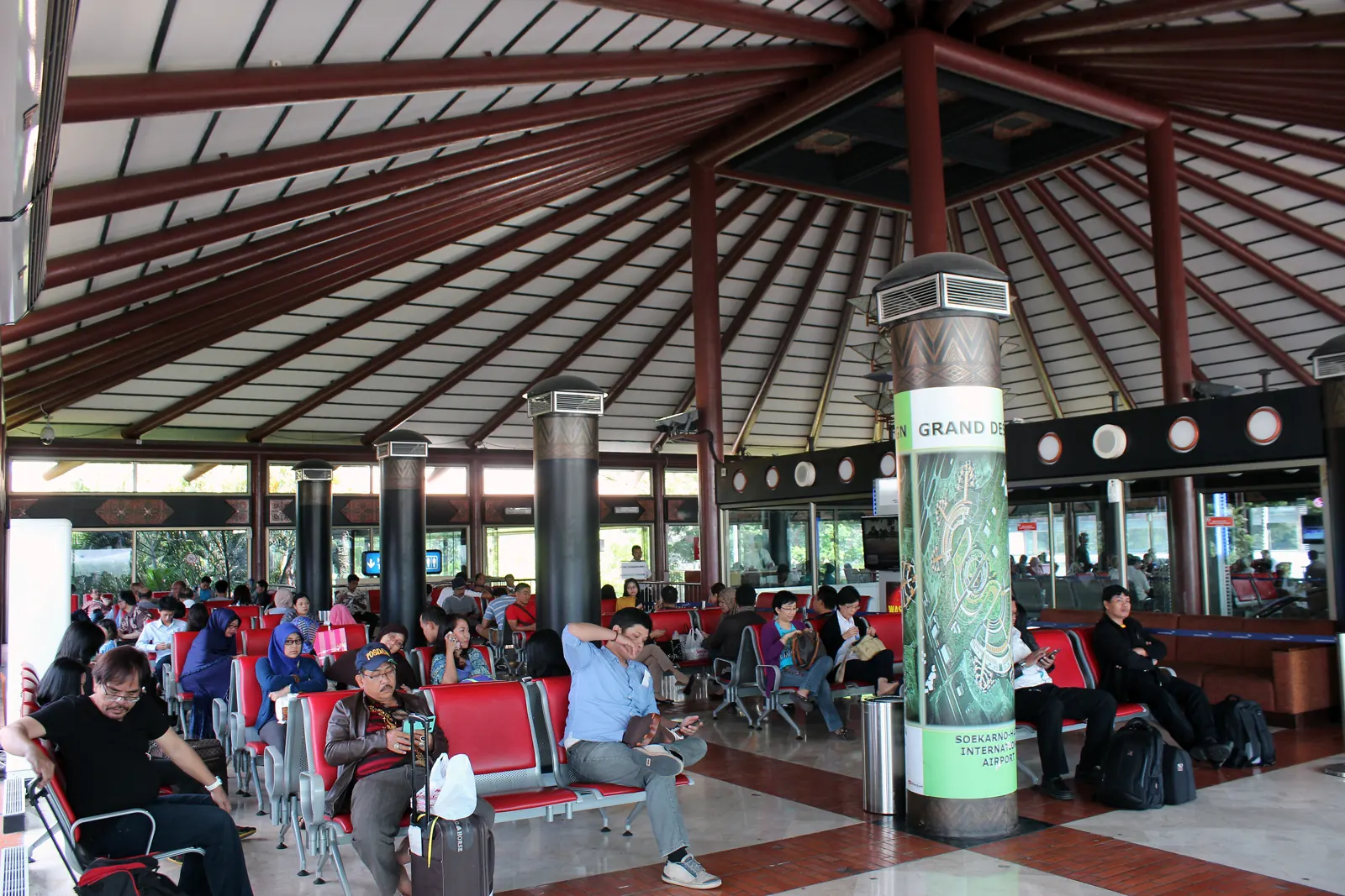 ruang tunggu Terminal 2 Bandara Soekarno-Hatta dengan atap kayu tinggi berbentuk paviliun, contoh arsitektur tropis modern