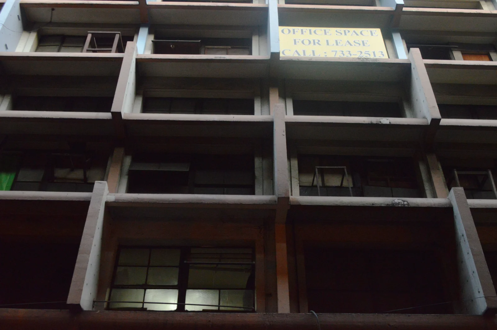 fasad gedung dengan sirip beton vertikal dan horizontal yang meneduhi jendela