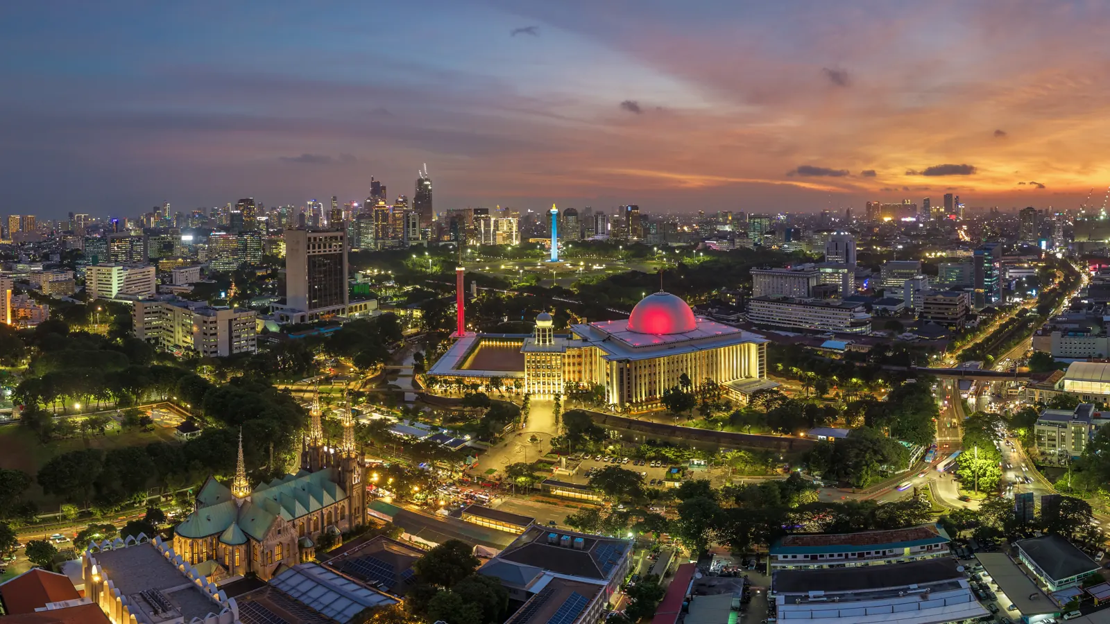 Masjid Istiqlal karya Friedrich Silaban dengan kubah menyala dan Gereja Katedral di senja hari