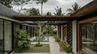 Atap rumah tropis hujan deras: rumah tropis dengan teritis atap lebar menaungi selasar dan taman
