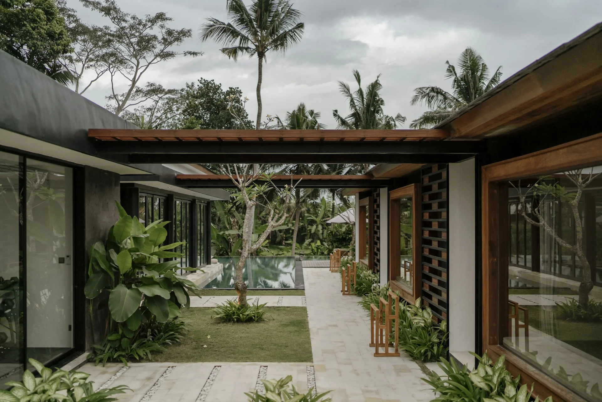 Atap rumah tropis teritis lebar Atap rumah tropis hujan deras: rumah tropis dengan teritis atap lebar menaungi selasar dan taman