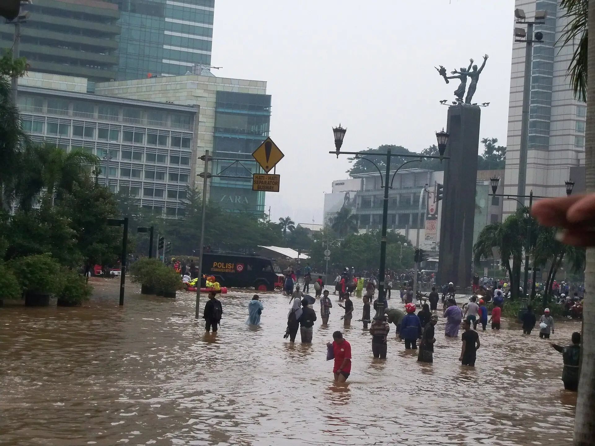 warga berjalan di jalan Jakarta yang tergenang