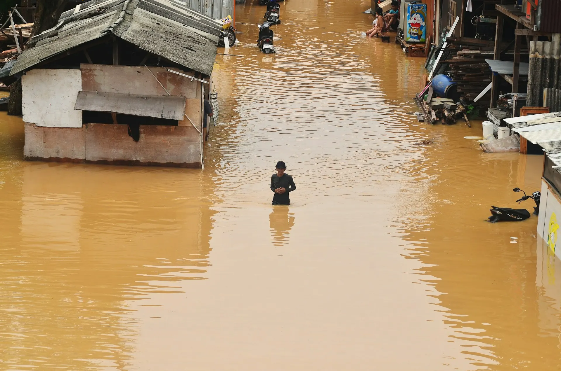 Banjir permukiman Rawa Jati Jakarta Warga berdiri di genangan banjir di antara rumah permukiman Rawa Jati, gambaran mengapa rumah anti banjir Jakarta dibutuhkan