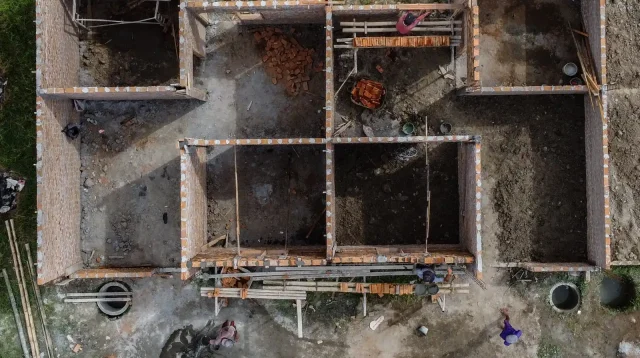 foto udara rumah yang sedang dibangun dengan dinding bata dan kolom beton