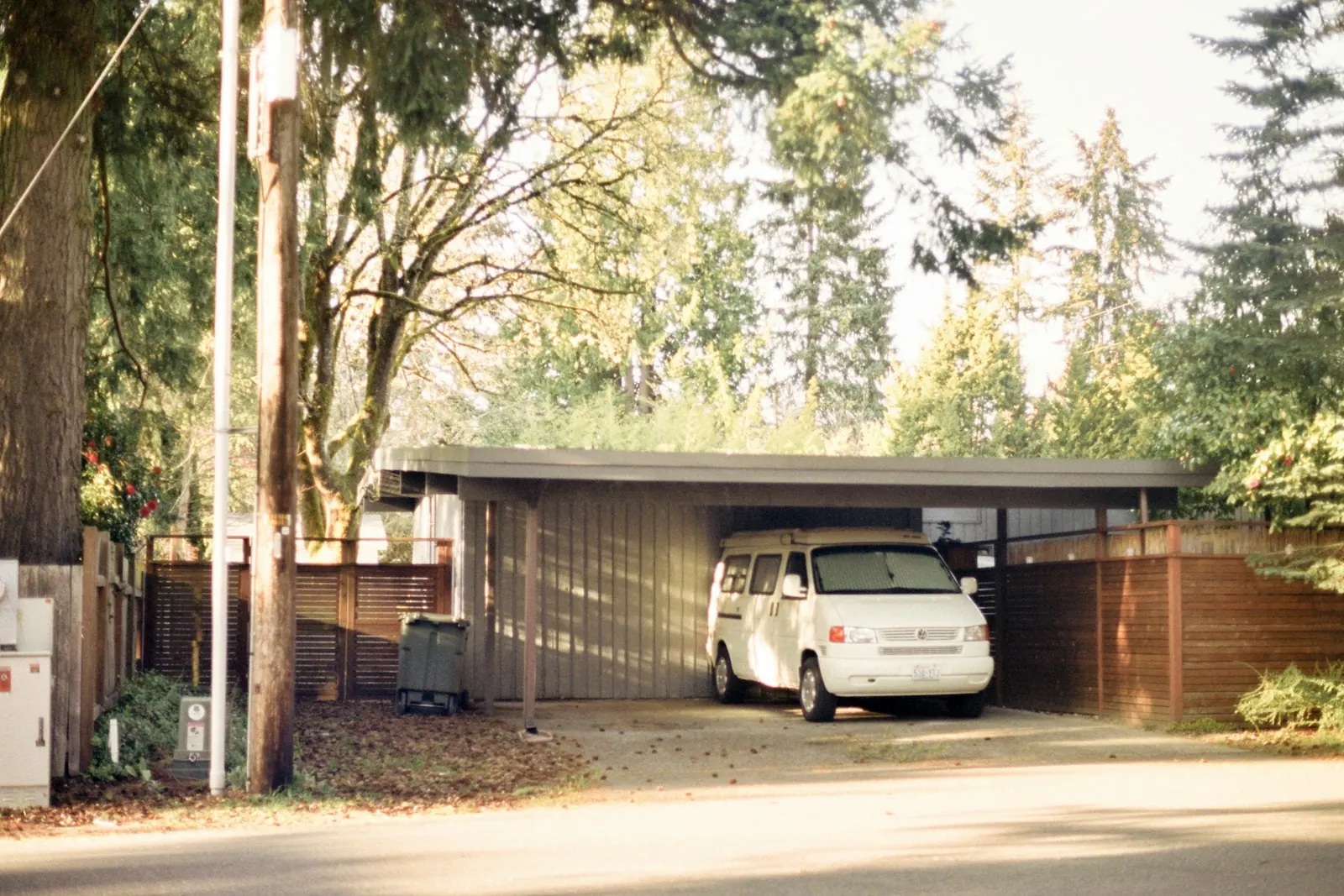 carport beratap datar dengan mobil di dalamnya