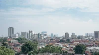 Permukiman rumah padat dengan latar gedung tinggi di kota