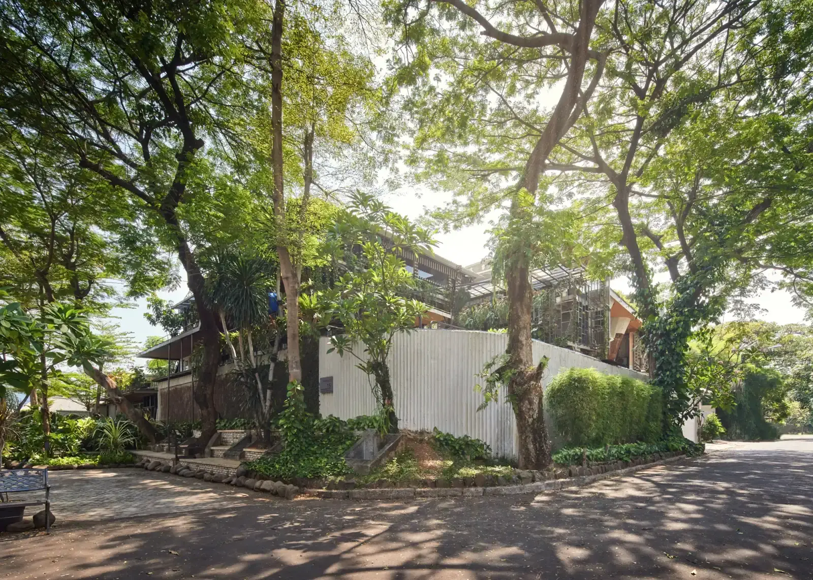 rumah Guha di sudut jalan yang tertutup rimbun pepohonan