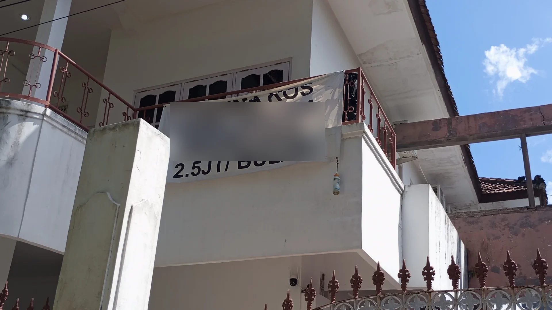 Izin rumah kost Jakarta: rumah dua lantai dengan spanduk terima kos