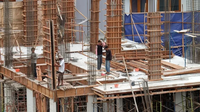 Rangka besi dan bekisting kolom beton bertulang di lantai dak bangunan bertingkat