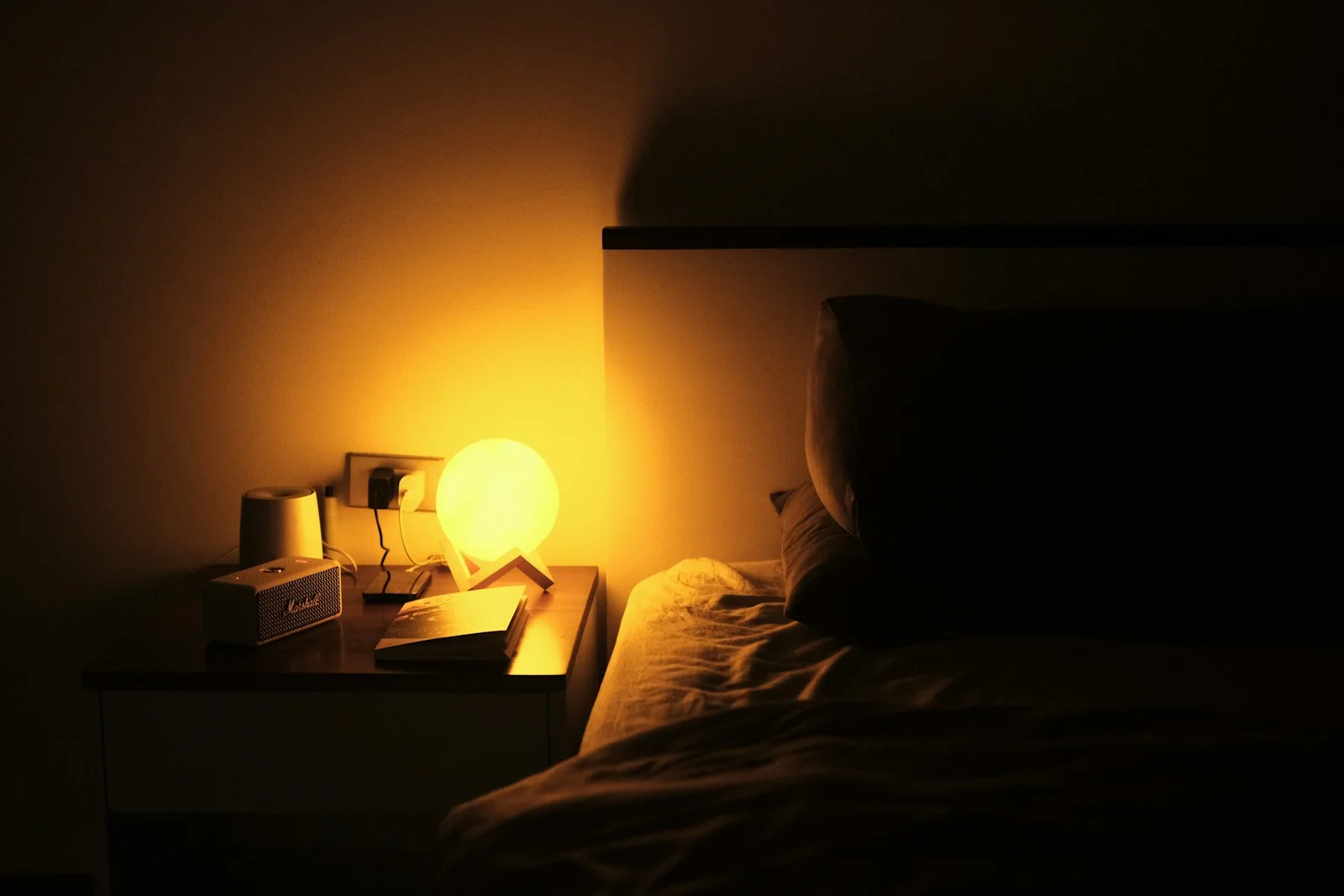 lampu meja warna hangat di samping tempat tidur