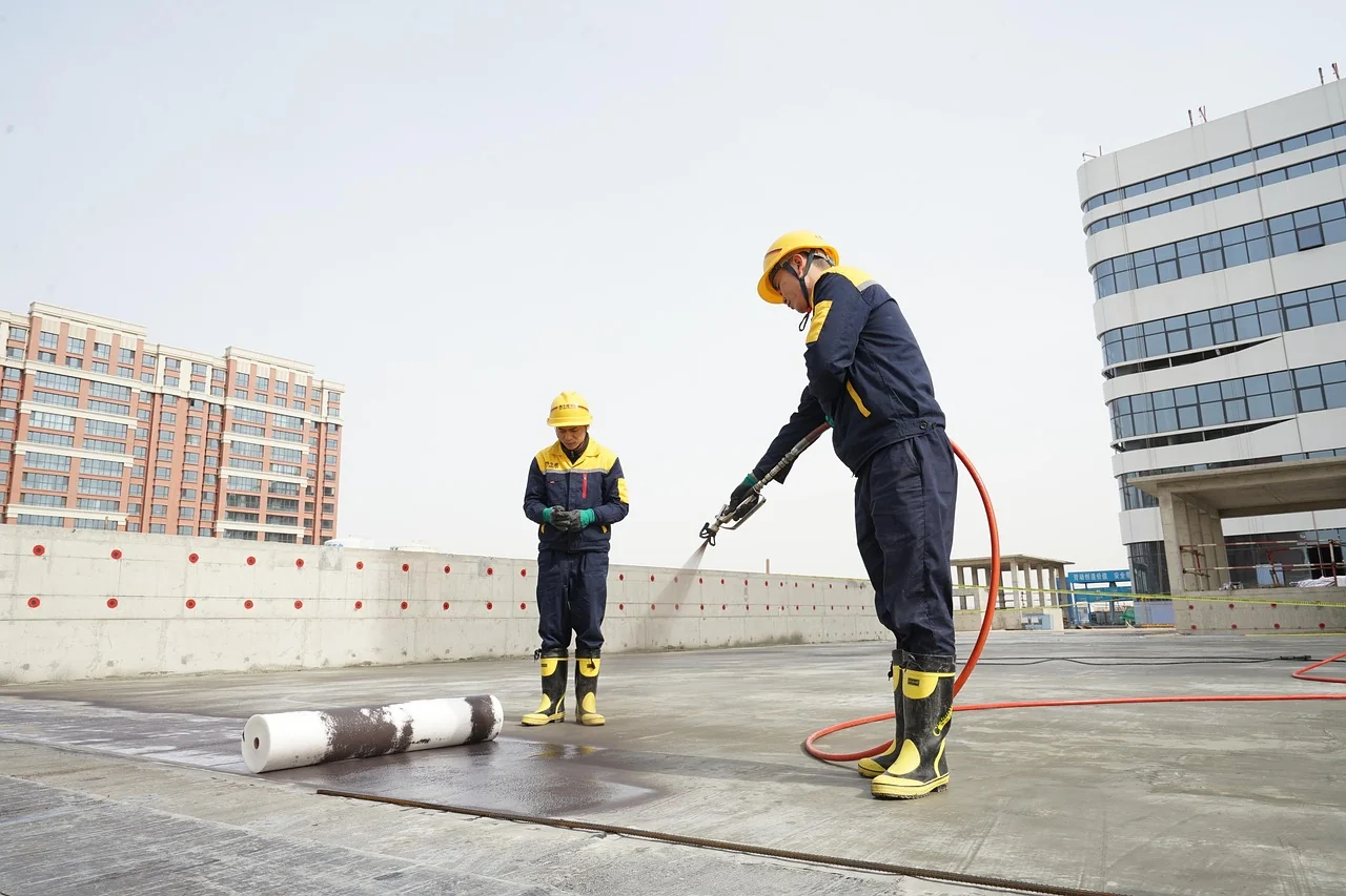 pekerja melapisi waterproofing di dak atap