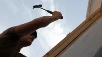 pemasangan-kusen-pintu-kayu tukang memaku ambang atas kusen pintu kayu pada dinding