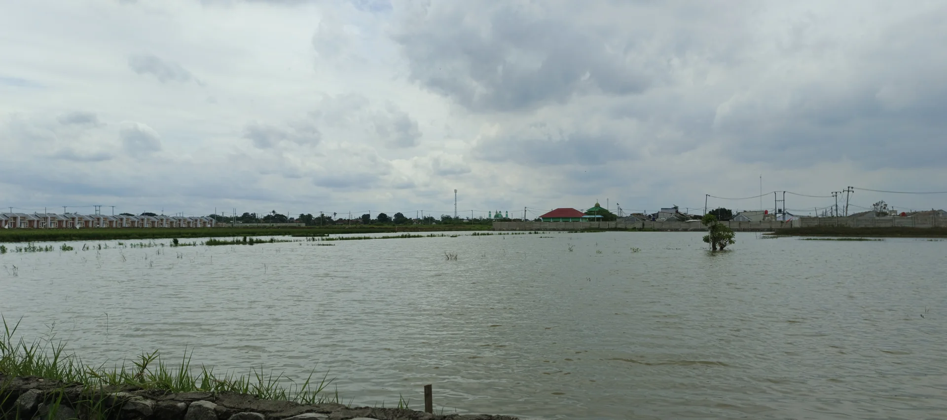 Deretan rumah perumahan Mahkota Village di Cibitung berbatasan dengan sawah yang tergenang air
