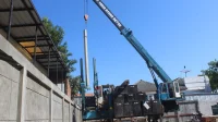 Mesin jack-in pile hidrolik mengangkat tiang pancang mini pile beton untuk pondasi dalam di lokasi proyek di antara rumah warga