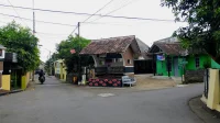 deretan rumah satu lantai sederhana di jalan perumahan