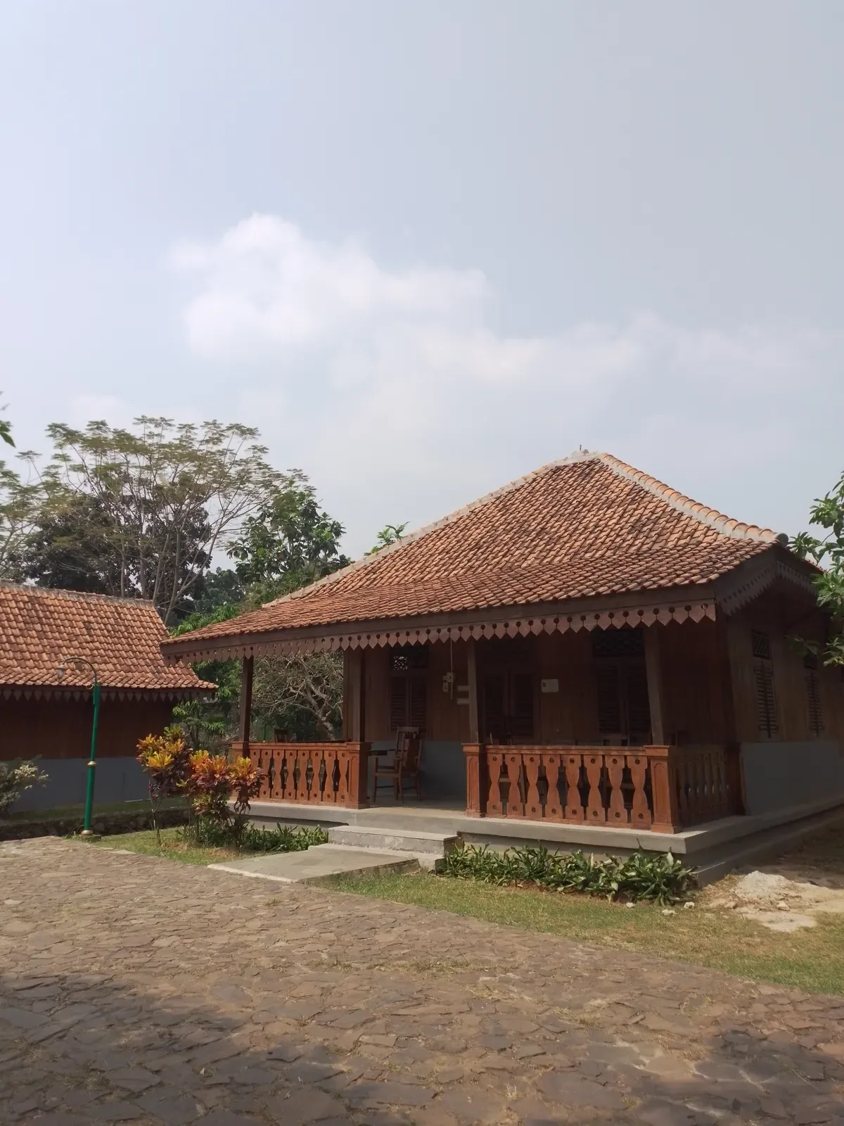 rumah Betawi beratap genteng dengan teras berlangkan kayu di Setu Babakan