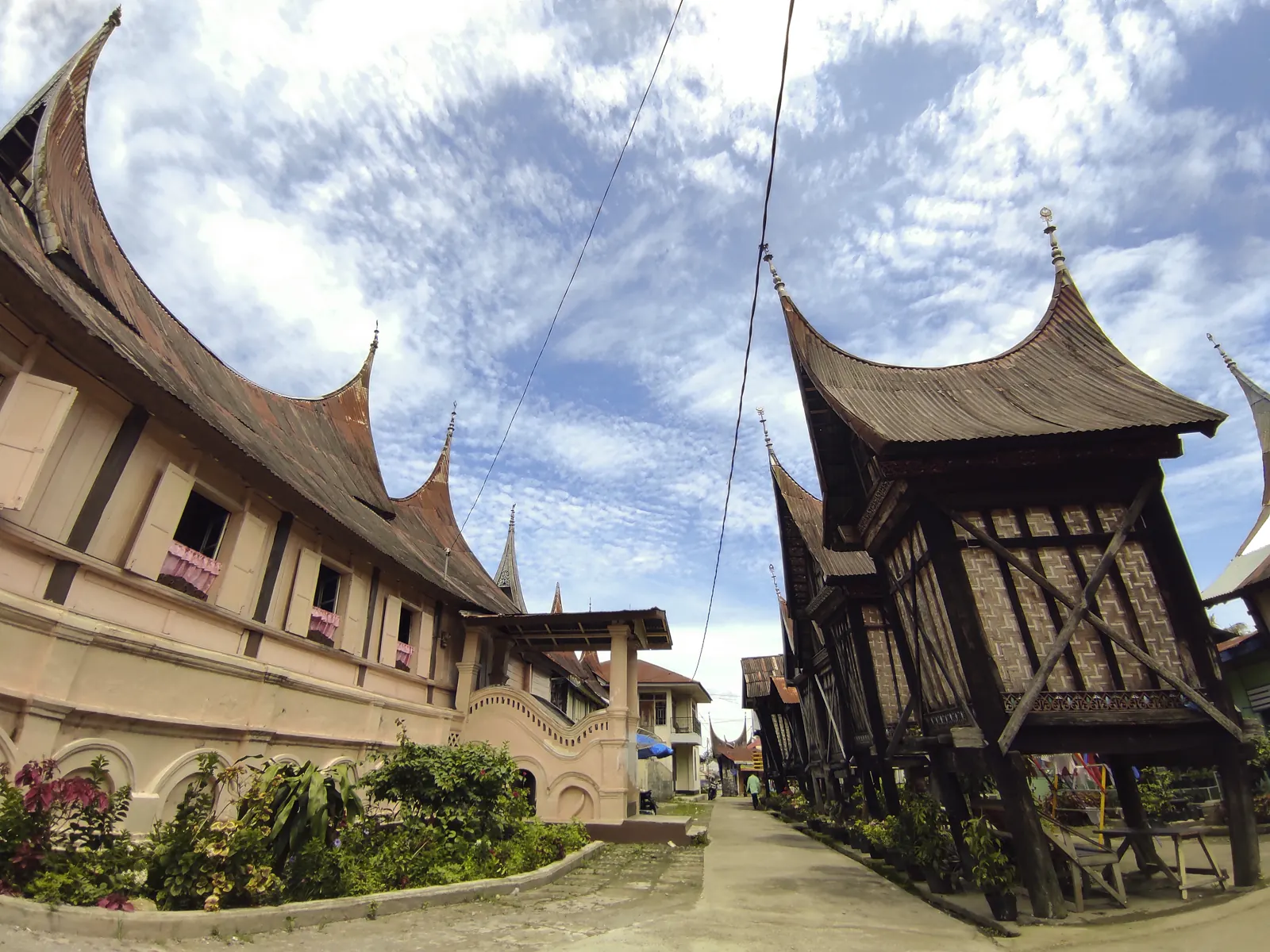Rumah Gadang beratap gonjong dengan lumbung rangkiang di halaman