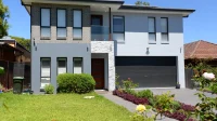 rumah modern dua lantai dengan fasad abu-abu dan carport