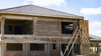 rumah sedang dibangun dengan dinding bata merah, kolom beton, dan perancah kayu