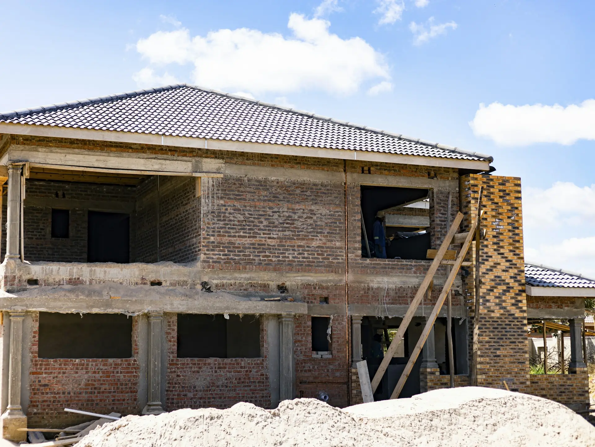 rumah-sedang-dibangun-tanpa-pbg rumah sedang dibangun dengan dinding bata merah, kolom beton, dan perancah kayu