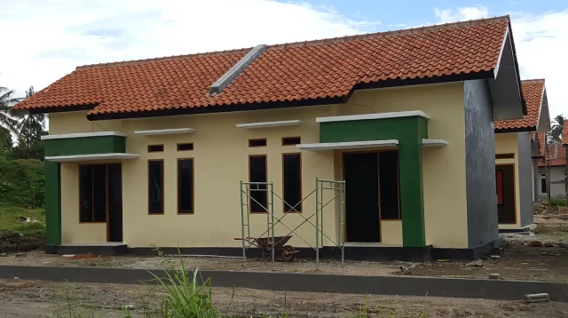 deretan rumah subsidi 2026 satu lantai bercat krem dengan kusen hijau