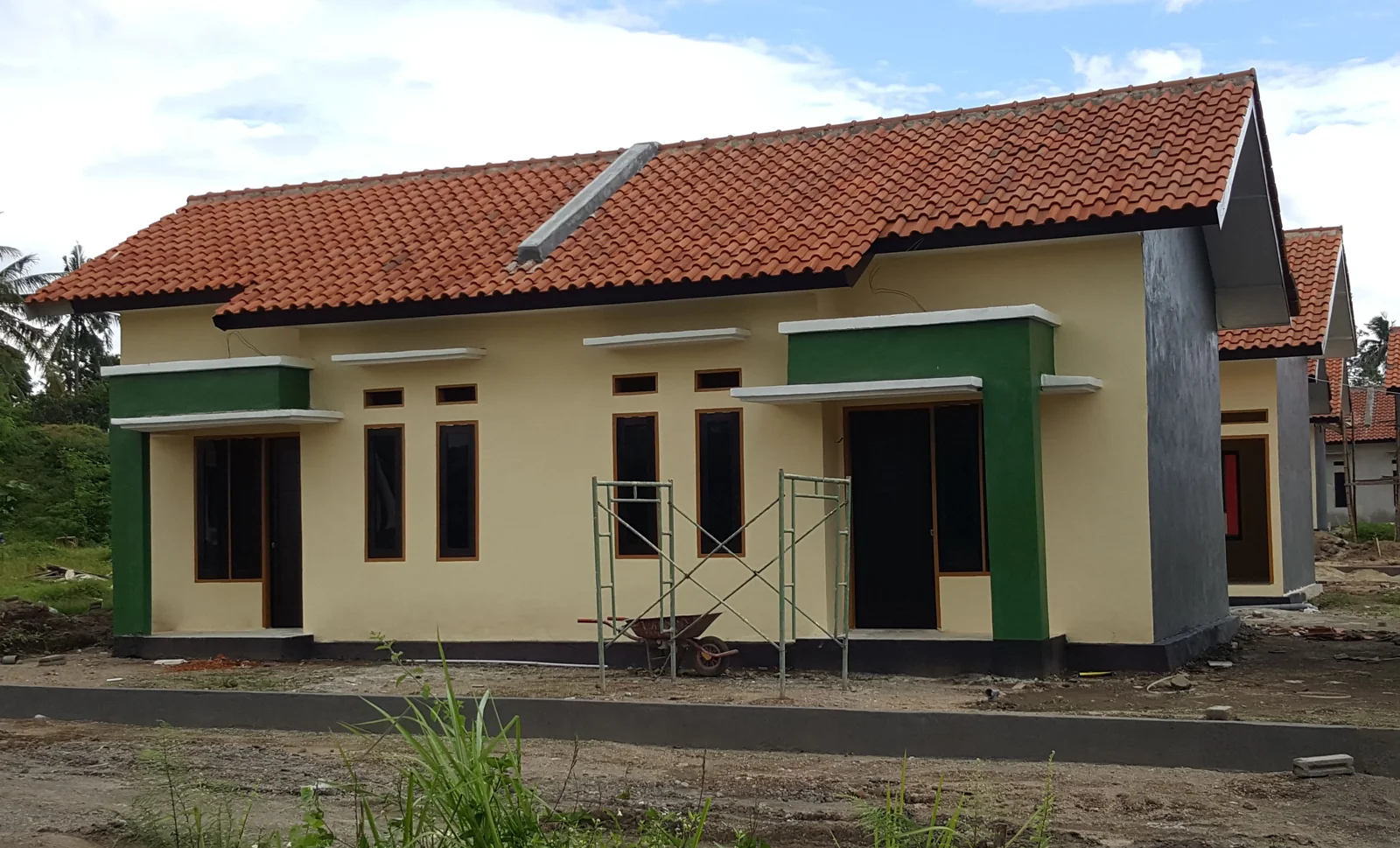 deretan rumah subsidi 2026 satu lantai bercat krem dengan kusen hijau