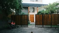 Rumah tinggal dua lantai berpagar kayu yang sudah dihuni
