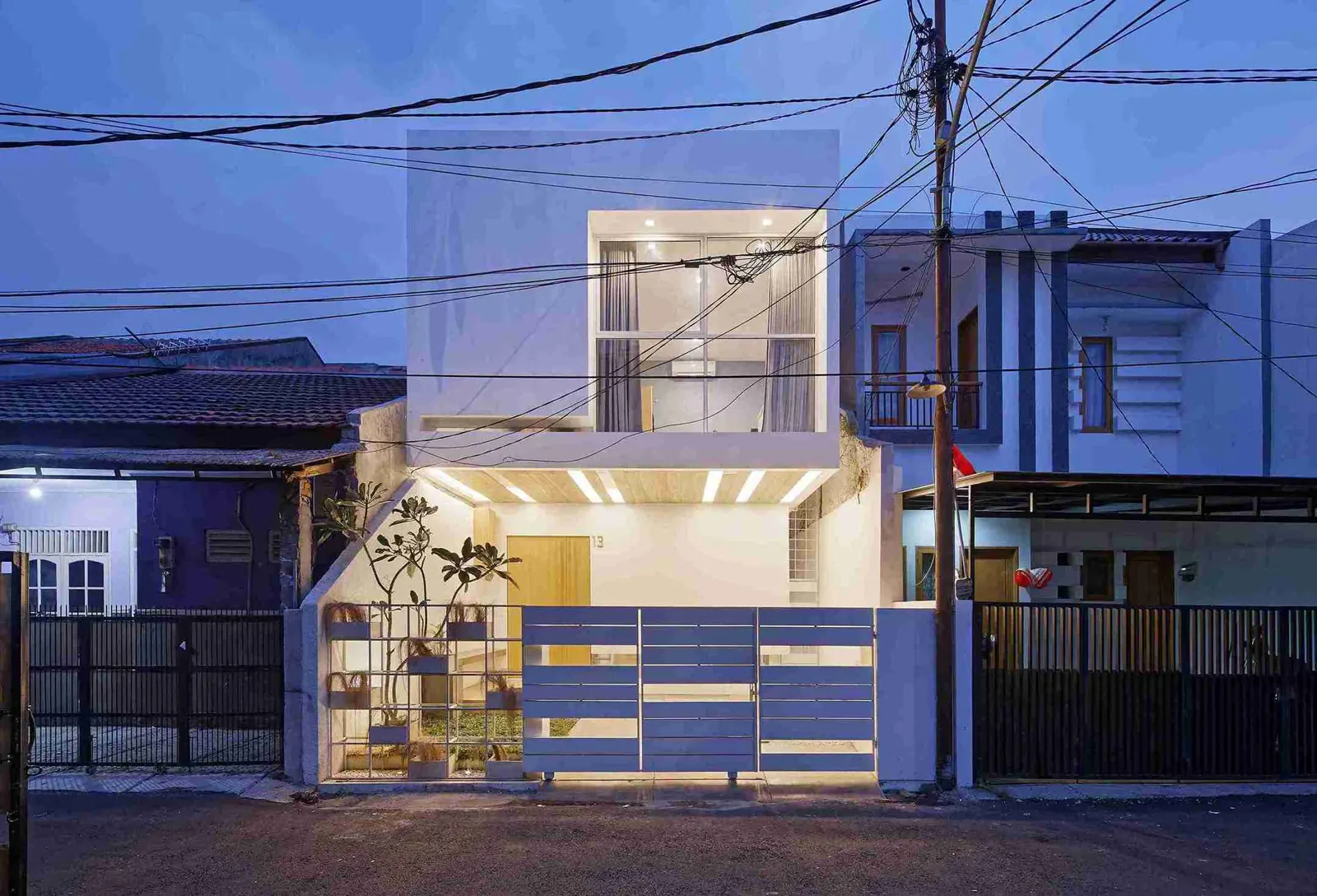 desain rumah lahan sempit Splow House tiga lantai di Tebet dengan fasad putih dan kanopi
