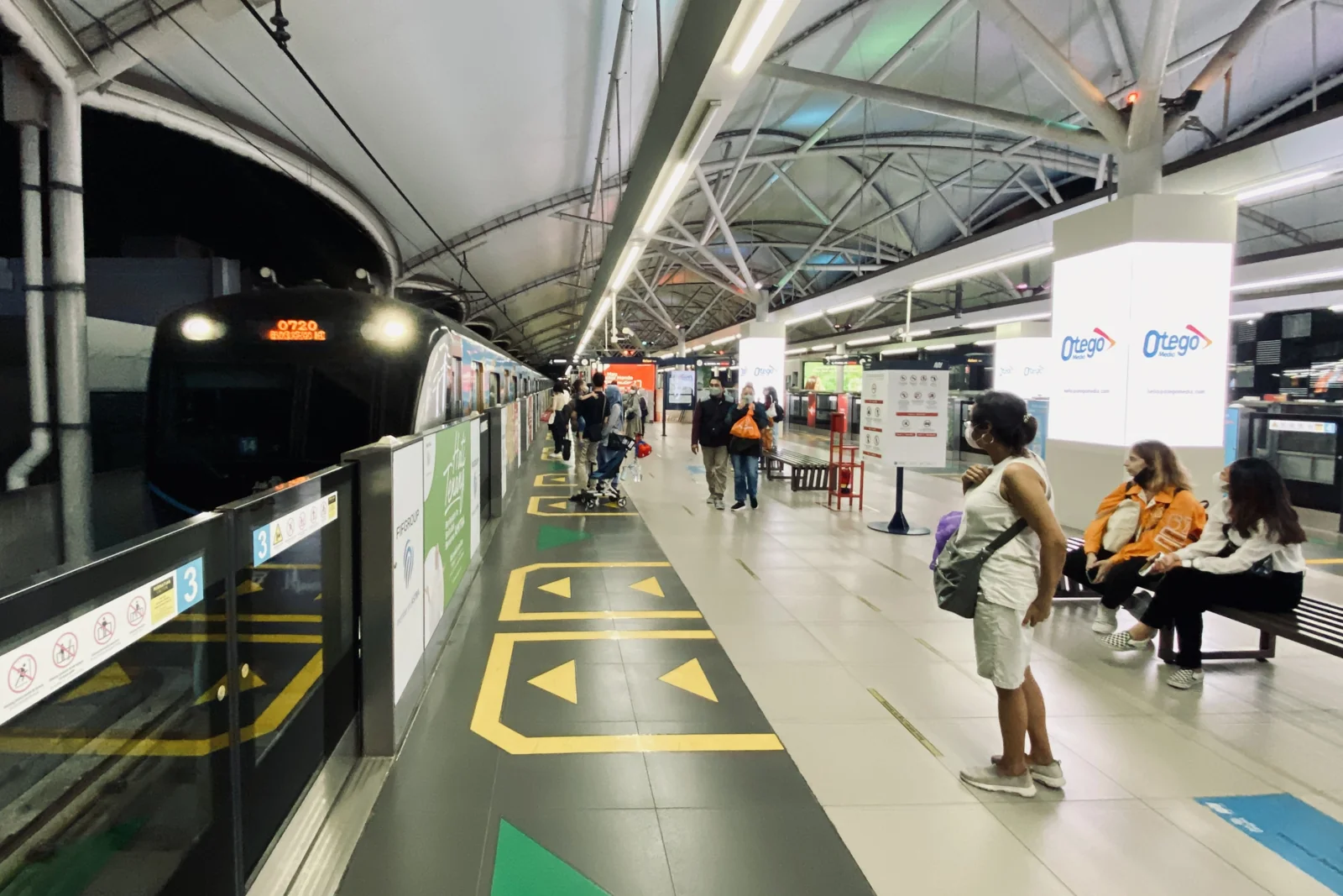 peron layang Stasiun MRT Blok M dengan kereta tiba dan penumpang menunggu