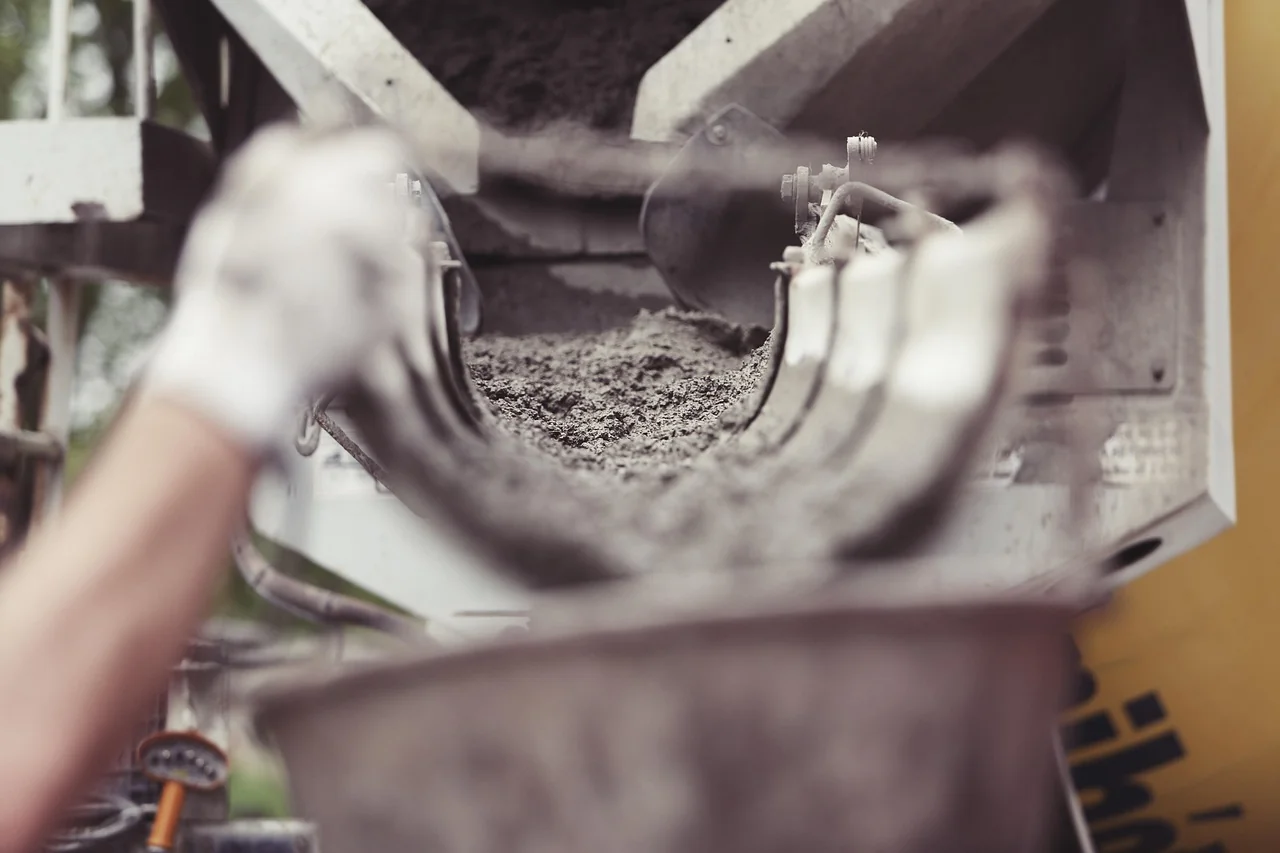 Beton segar mengalir dari talang truk mixer ready mix ke wadah
