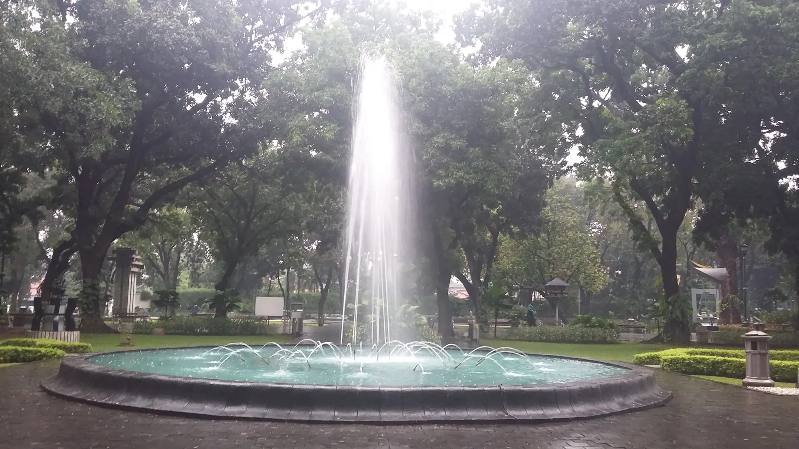 air mancur di bawah pohon rindang Taman Suropati