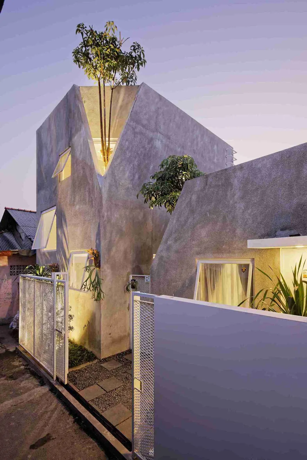 dua massa rumah beton ekspos bersebelahan dengan jendela vertikal di Cipulir