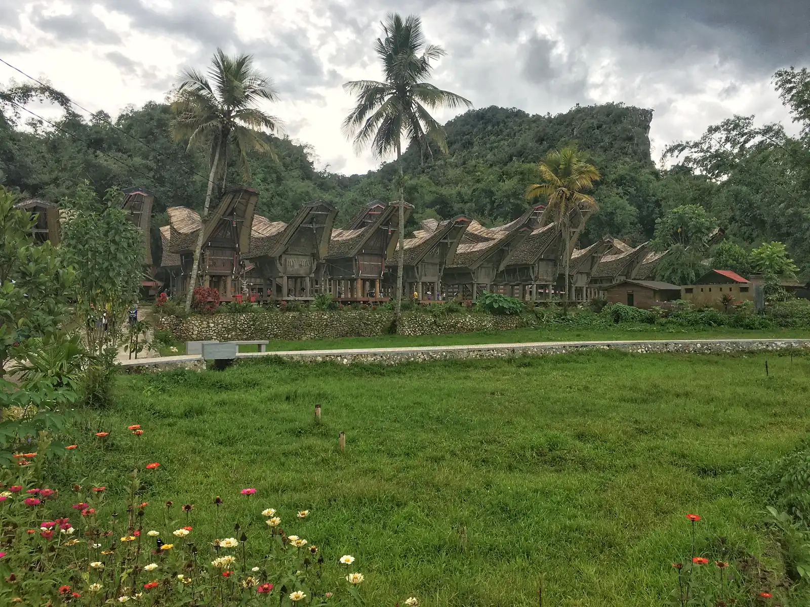 rumah Tongkonan panggung dengan atap melengkung dan dinding berukir