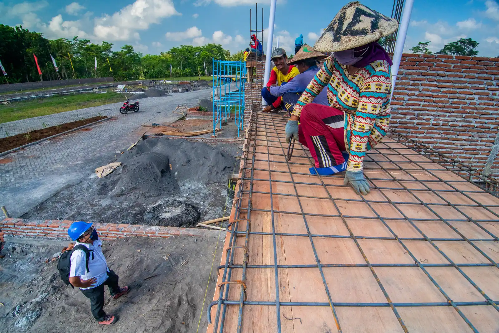 pekerja memasang tulangan besi pelat beton di lokasi proyek
